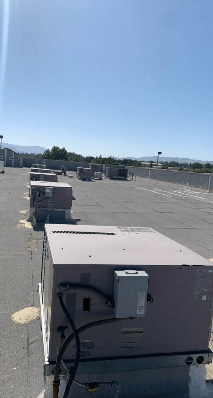Row of packaged rooftop HVAC units on a commercial building inspected during an indoor air quality assessment.