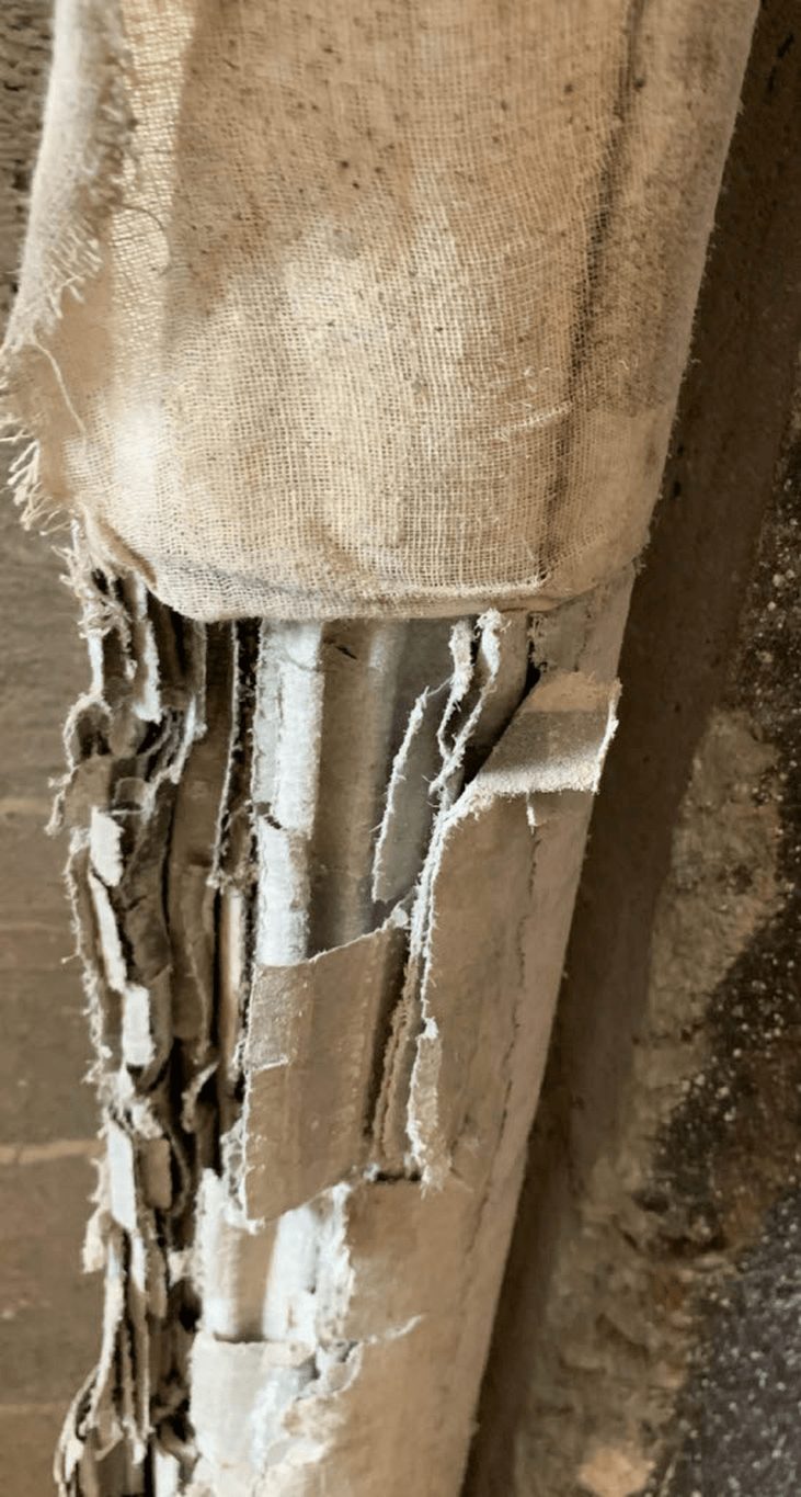 Torn canvas jacket on pipe insulation exposing friable material, sampled during an asbestos survey in Ventura County.